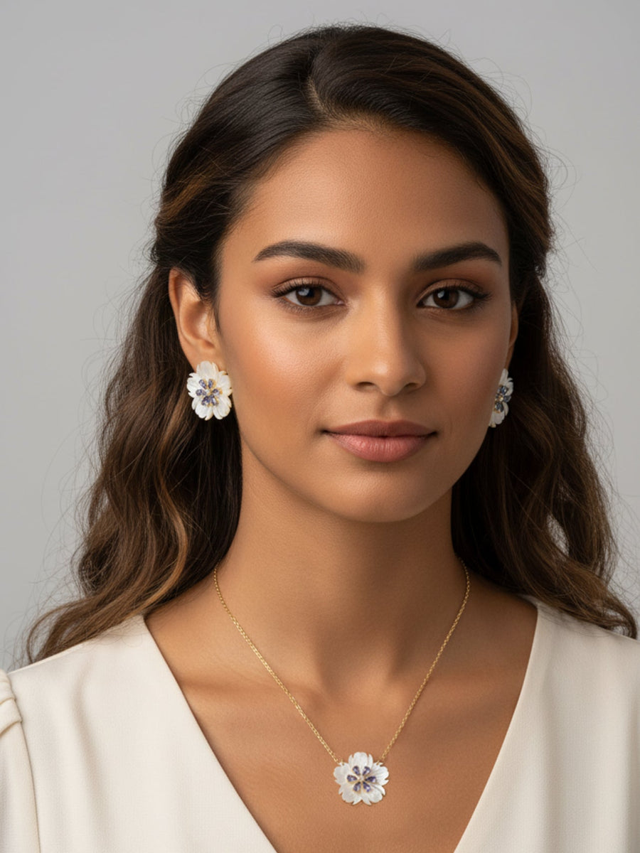 Woman wearing a MOP Flower shape necklace and earrings with a neutral background